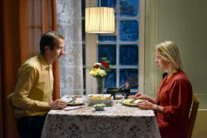 Un homme et une femme dînent à table photo du film Les feuilles mortes
