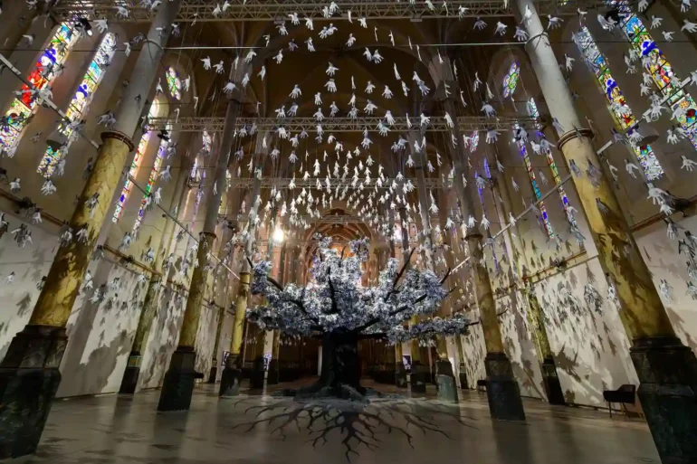 nstallation “Adventice” de JR au Carré Sainte-Anne de Montpellier, arbre monumental composé de milliers d’empreintes de mains.