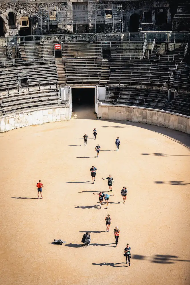 Participants du Nîmes Urban Trail 2026 en pleine course dans une ambiance festive à Nîmes.