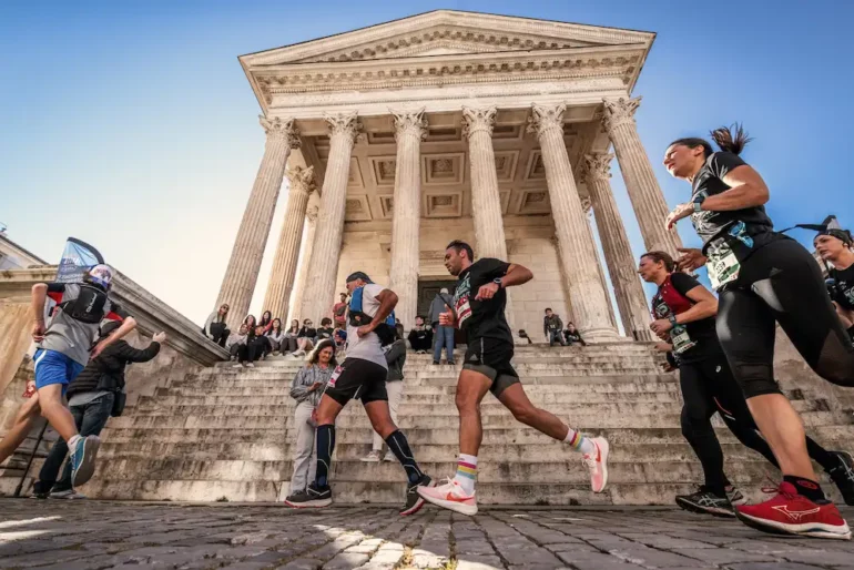 Participants du Nîmes Urban Trail 2026 en pleine course dans une ambiance festive à Nîmes.